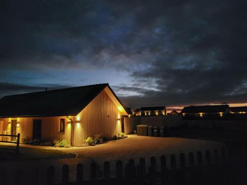 a building with lights on the side of it at night at White Swan Cottage - Ukc4640 in Dunholme