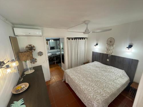 a bedroom with a bed and a table and a mirror at Ti coin de paradis Anse des Rochers in Saint-François
