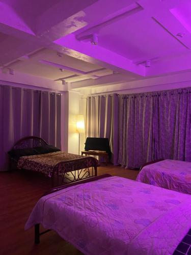 a room with two beds and a purple ceiling at Valdez & Ismail HOMESTAY in Apatot
