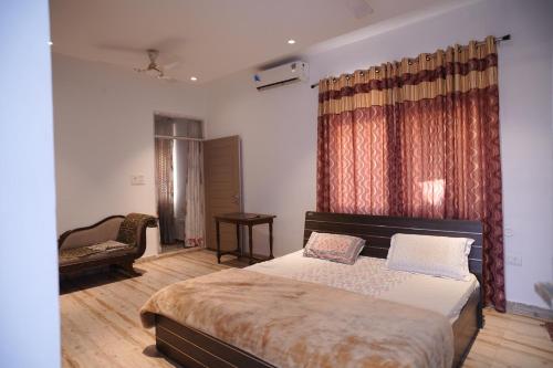 a bedroom with a bed and a chair at royal palace and resort in Sultānpur