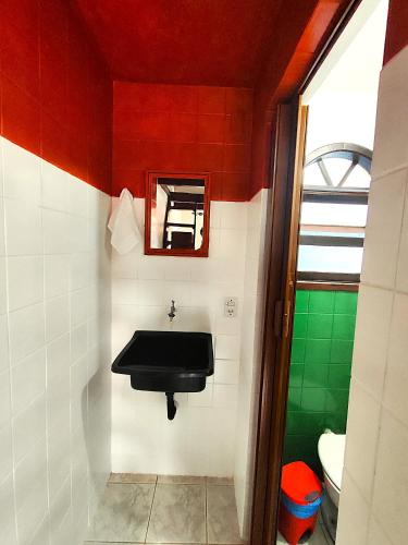a bathroom with a black sink and a mirror at Pousada Em Busca do Sol in Trindade