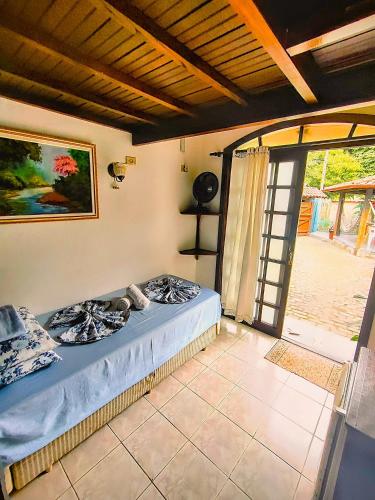 a bed sitting in a room with a window at Pousada Em Busca do Sol in Trindade