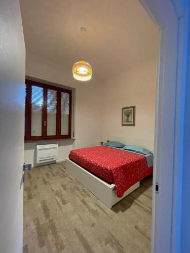 a bedroom with a red bed and a window at Teodolinda in Trezzo sullʼAdda