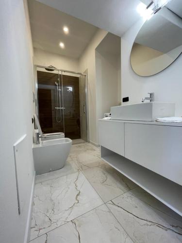 a white bathroom with a sink and a mirror at Teodolinda in Trezzo sullʼAdda