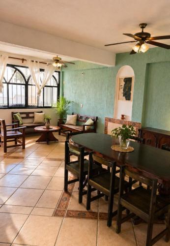 a room with tables and chairs and a ceiling fan at Casa Cultivo in Brisas de Zicatela