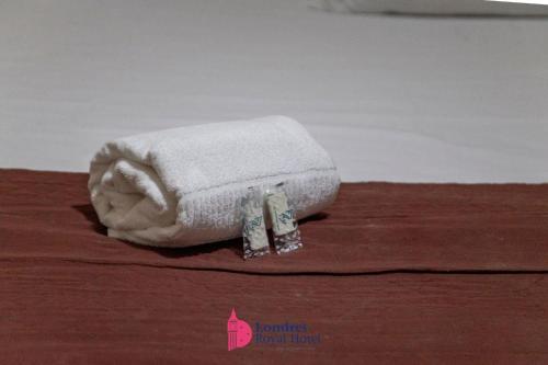 a towel with two tags on it sitting on a table at Londres Royal Hotel in Londrina