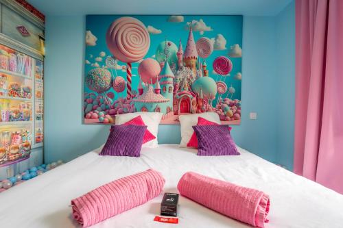 a bedroom with a large bed with pink pillows at Le Candy by Clem in Pélussin