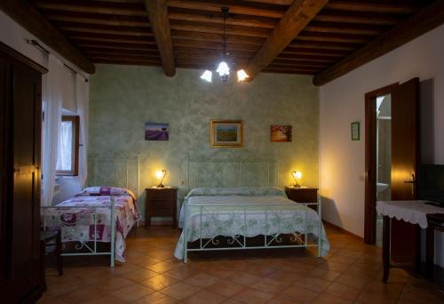 a bedroom with two beds and two lamps on tables at Agriturismo Il Capannone in Montemerano