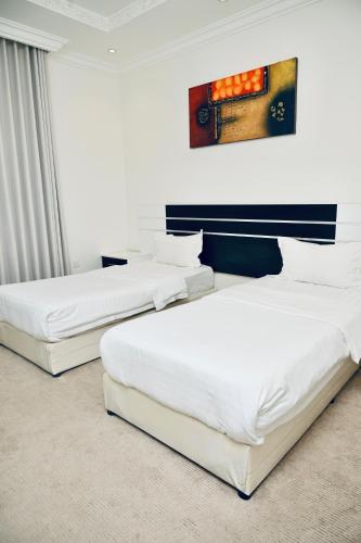 two beds in a hotel room with white walls at روعة نجد القدس in Riyadh