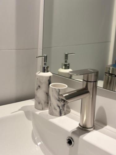 a bathroom sink with a silver faucet and a mirror at Nova Studio Dpto nuevo a pasos de Av Alemania in Temuco