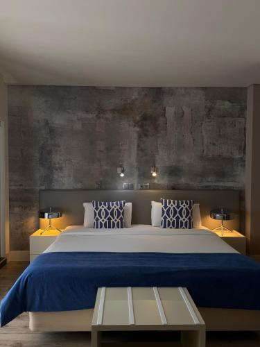a bedroom with a large bed with a blue blanket at Aqua Ria Boutique Hotel in Faro