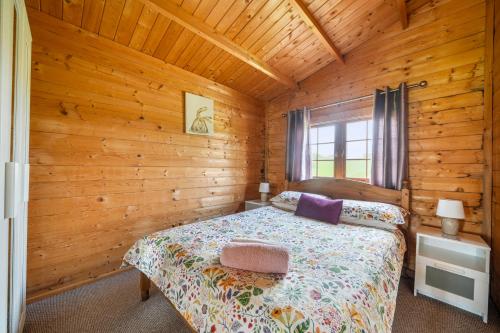 a bedroom with a bed in a wooden cabin at Moor View Cabin (Oak Tree Lane) in Okehampton