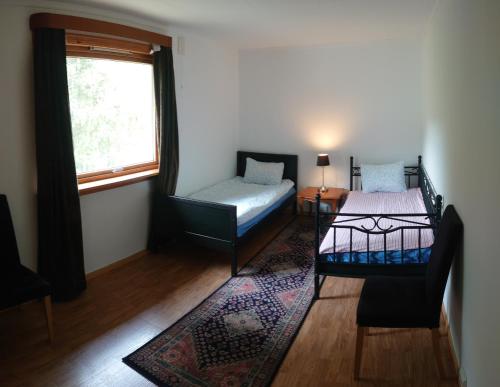 a bedroom with a bed and a chair and a window at Two bedroom Apartment 80m2 2nd floor in Bagn