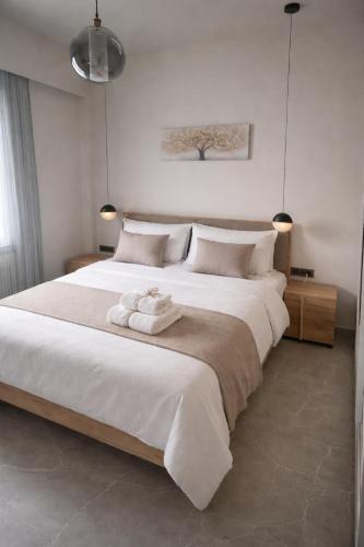 a bedroom with a large white bed with towels on it at Memories in Tinos