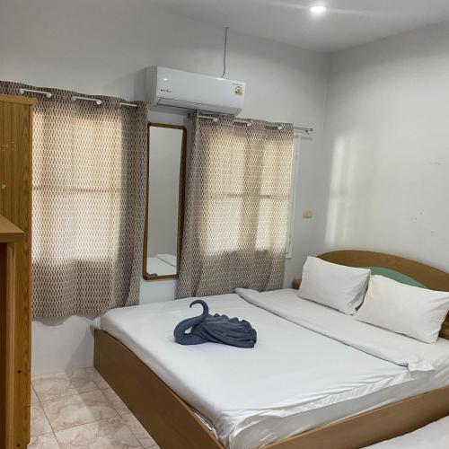 a bedroom with two beds and a towel on the bed at Good Villa by Saran in Krabi