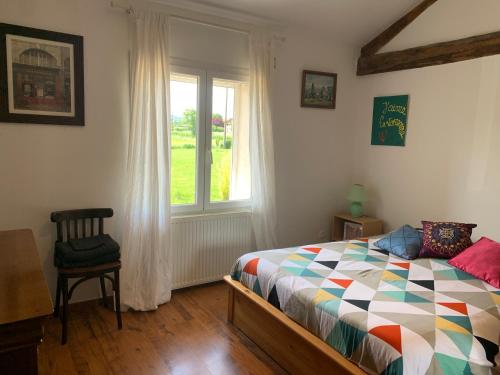 a bedroom with a bed and a window at La Varenne in Changy