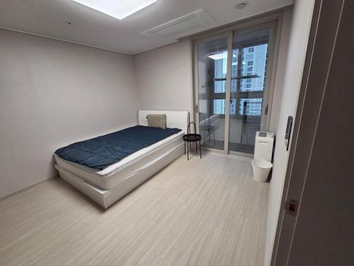 a white bedroom with a bed and a window at 청라 스테이 22층 뷰 공항 송도 검단 김포 in Kojan