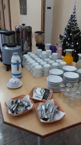 Hotel El Parque في سان كليمنتي ديل تويو: طاولة عليها صحون وصحون بيضاء
