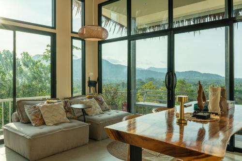 a living room with a table and chairs and windows at Archie Paradise View in Thong Sala
