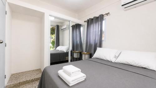 a bedroom with a bed with two white towels on it at Harmonia - Sunbeha resort, Juan Dolio in Juan Dolio