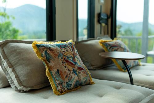 a living room with two couches and a table at Archie Paradise View in Thong Sala