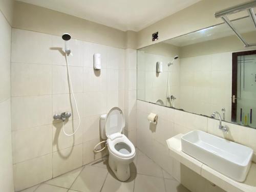 a bathroom with a shower and a toilet and a sink at Urbanview Hotel Ratna Syariah in Sukobumi