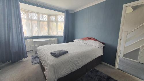 a blue bedroom with a bed with a red pillow at Wigston house in Wigston Magna