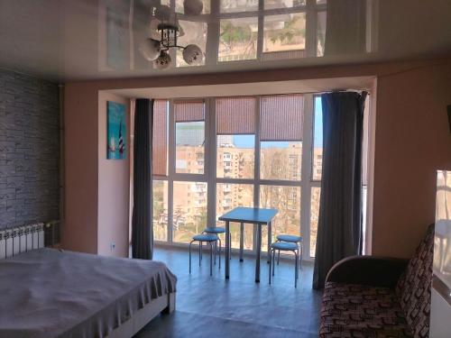 a bedroom with a table and chairs in front of a window at Морской дом in Odesa