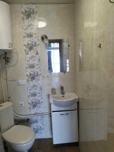 a bathroom with a toilet and a sink and a shower at Морской дом in Odesa