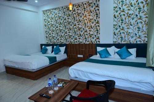 a hotel room with two beds and a table at Hotel JR Palace- Near Toran Dwar and free Parking in Khātu