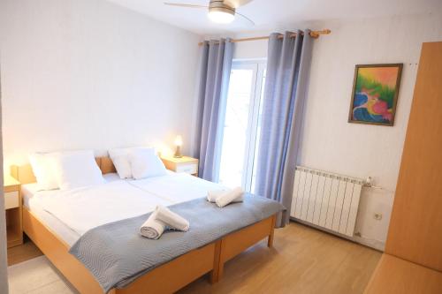 a bedroom with a bed with two towels on it at Piadora in Banjol