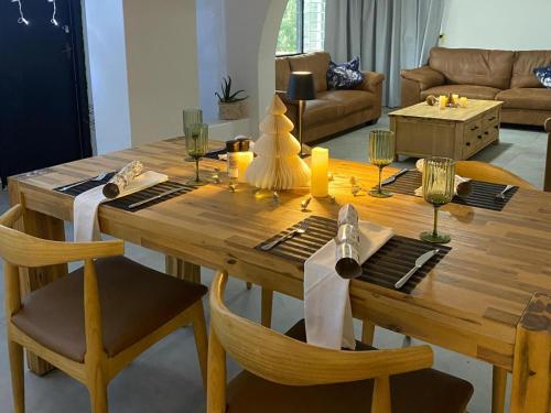 a wooden table with chairs and wine glasses on it at The Bay View Hotel in Richards Bay