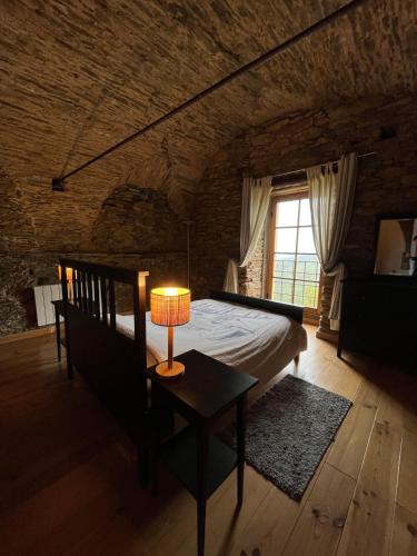 a bedroom with a bed and a lamp on a table at Domaine Santa Petronilla "chapelle" in Rogliano