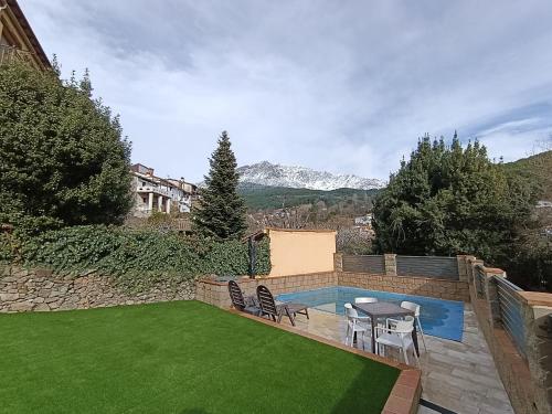 a backyard with a pool and a table and chairs at Casa La Rubía de Gredos in Cuevas del Valle