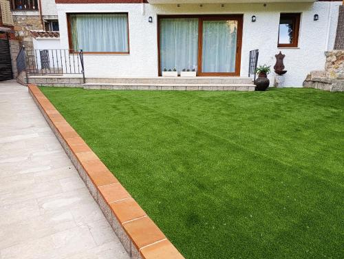 a house with a lawn in front of a house at Casa La Rubía de Gredos in Cuevas del Valle