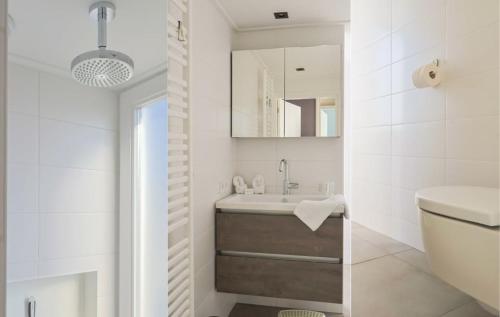 a white bathroom with a sink and a mirror at Villa Verderop - Luxury Lakeside Villa with Terrace & Water Views in Friesland in Boornzwaag