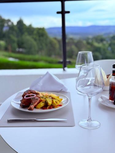 a plate of food on a table with wine glasses at Boynuz Hotels in Nyahururu