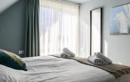 a bedroom with a bed with towels on it at Villa Verderop - Luxury Lakeside Villa with Terrace & Water Views in Friesland in Boornzwaag