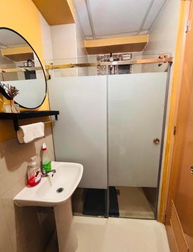a bathroom with a shower and a sink and a mirror at RR 21 Milan Residenze Fairview in Manila