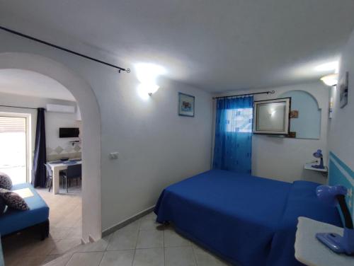 a bedroom with a blue bed and a couch at Appartamenti Conchiglie e Stelle Marine in Cala Gonone