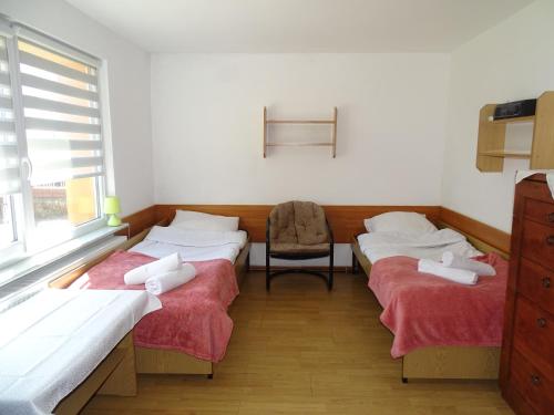 a room with three beds and a chair in it at Orwsnoch in Mielno