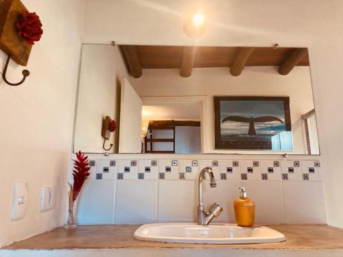 a kitchen counter with a sink and a mirror at Flats Bon Voyage Caboré - Chez Cira in Paraty