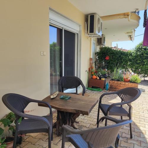 a wooden table and chairs on a patio at Serene Vintage in Nea Moudania