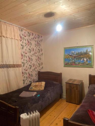 a bedroom with two beds and a painting on the wall at noras guesthauze 2026 in Zhabeshi
