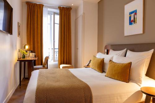 a hotel room with a bed and a window at Europe Hotel Paris Eiffel in Paris
