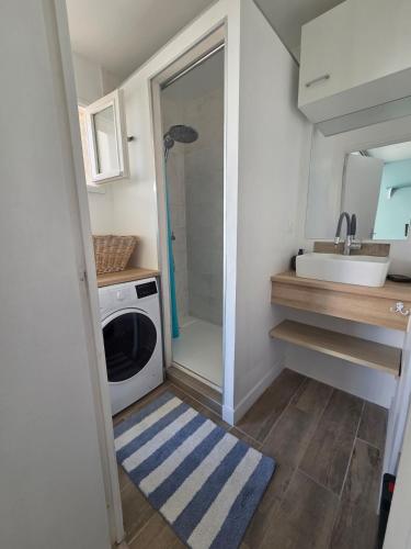 a small kitchen with a washing machine and a sink at La Parenthèse, studio in Gruissan