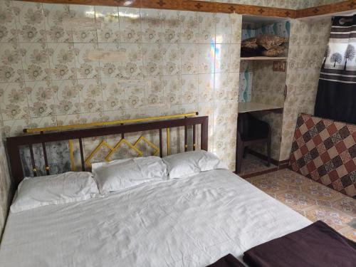 a bed with white sheets and pillows in a bedroom at ADwarkesh femily homestay in Dwarka