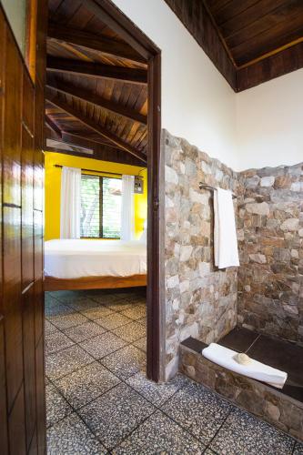 a bedroom with a bed and a stone wall at Tides Oceanfront Resort in Santa Cruz