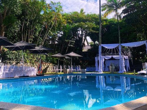 a large swimming pool with chairs and umbrellas at The Bay View Hotel in Richards Bay
