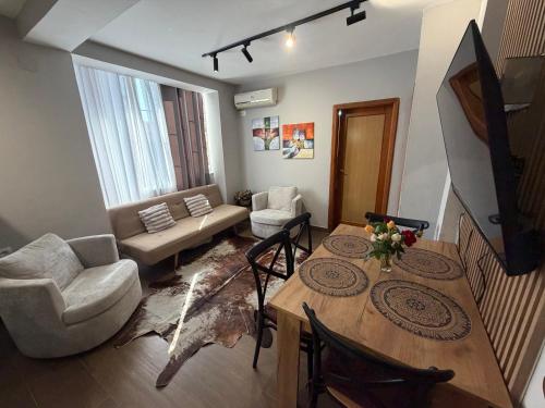 a living room with a table and chairs and a couch at Sunny hill Apartment in Golem